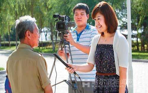 哈报集团全媒体记者在街头进行采访